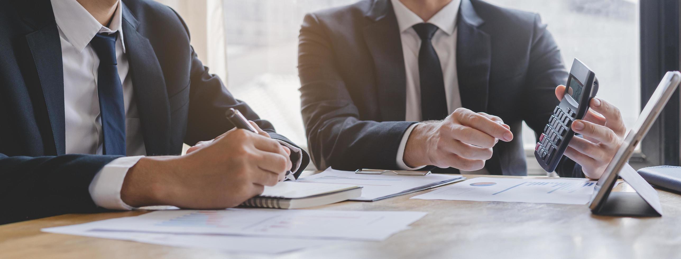 o negócio reunião, dois caucasiano, ásia Yong grupo homem chuva de ideias analisando em gráfico dados do custo plano ou documento, papelada e discutindo dentro borda quarto em mesa. pessoas trabalhando conferência sala. foto