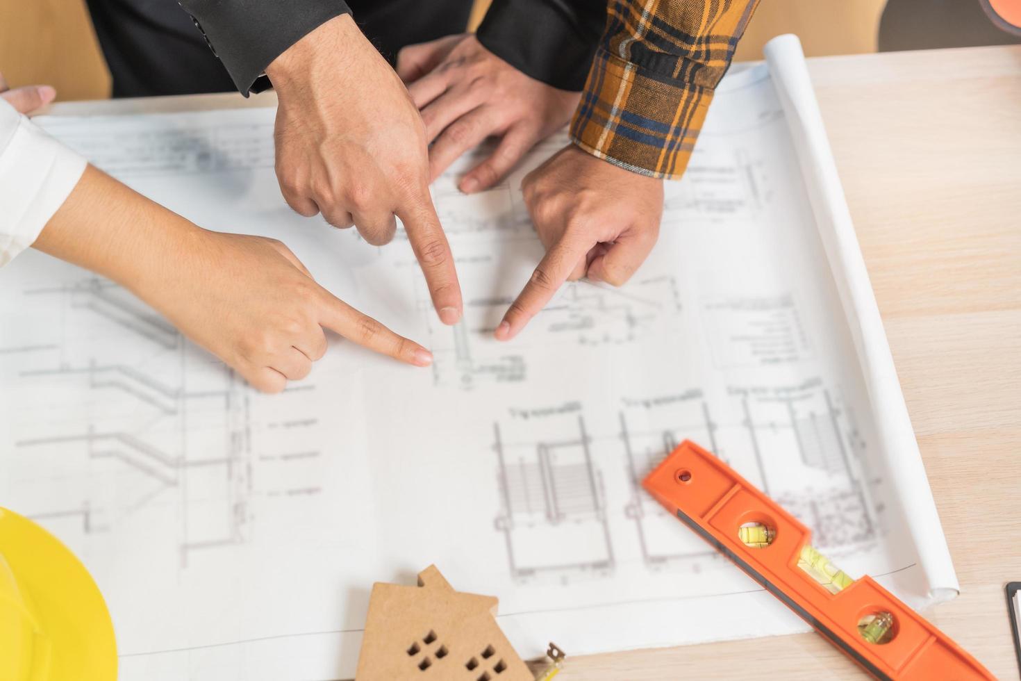 construtor equipe, ásia jovem engenheiro homem, masculino e arquiteto mulher estão discutindo construção em projeto para Segue a projeto para Construir a industrial plano às local. engenheiro trabalhador pessoas conceito. foto