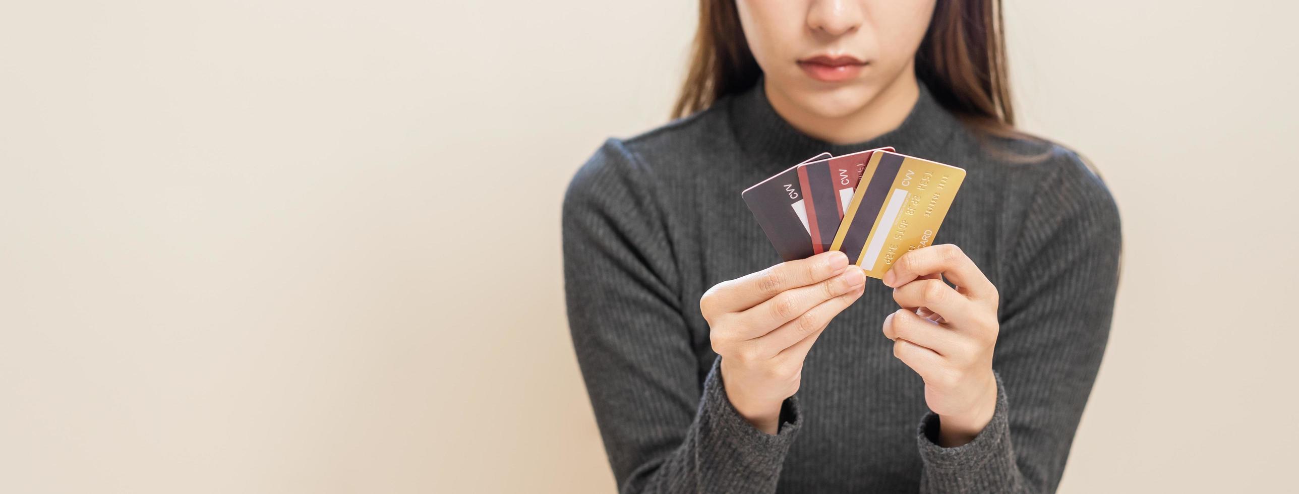 financeiro dever, mão do ásia mulher, menina mão dentro contenção, olhando às muitos crédito cartão, estressado de calcular despesa a partir de conta, não dinheiro para pagar, hipoteca ou empréstimo. dívida, falência ou falido. foto