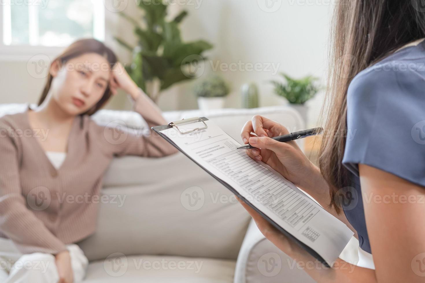 psicologia, depressão. triste, sofrimento ásia jovem mulher consultando com psicólogo, psiquiatra enquanto paciente aconselhamento mental com médico mulher levando notas às clínica. encorajando, terapia. foto