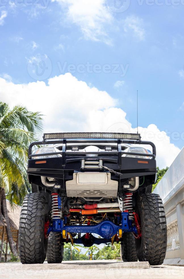 baixo visualizar, fechar-se, frente debaixo estrutura do Preto carro com grande rodas estacionado. foto