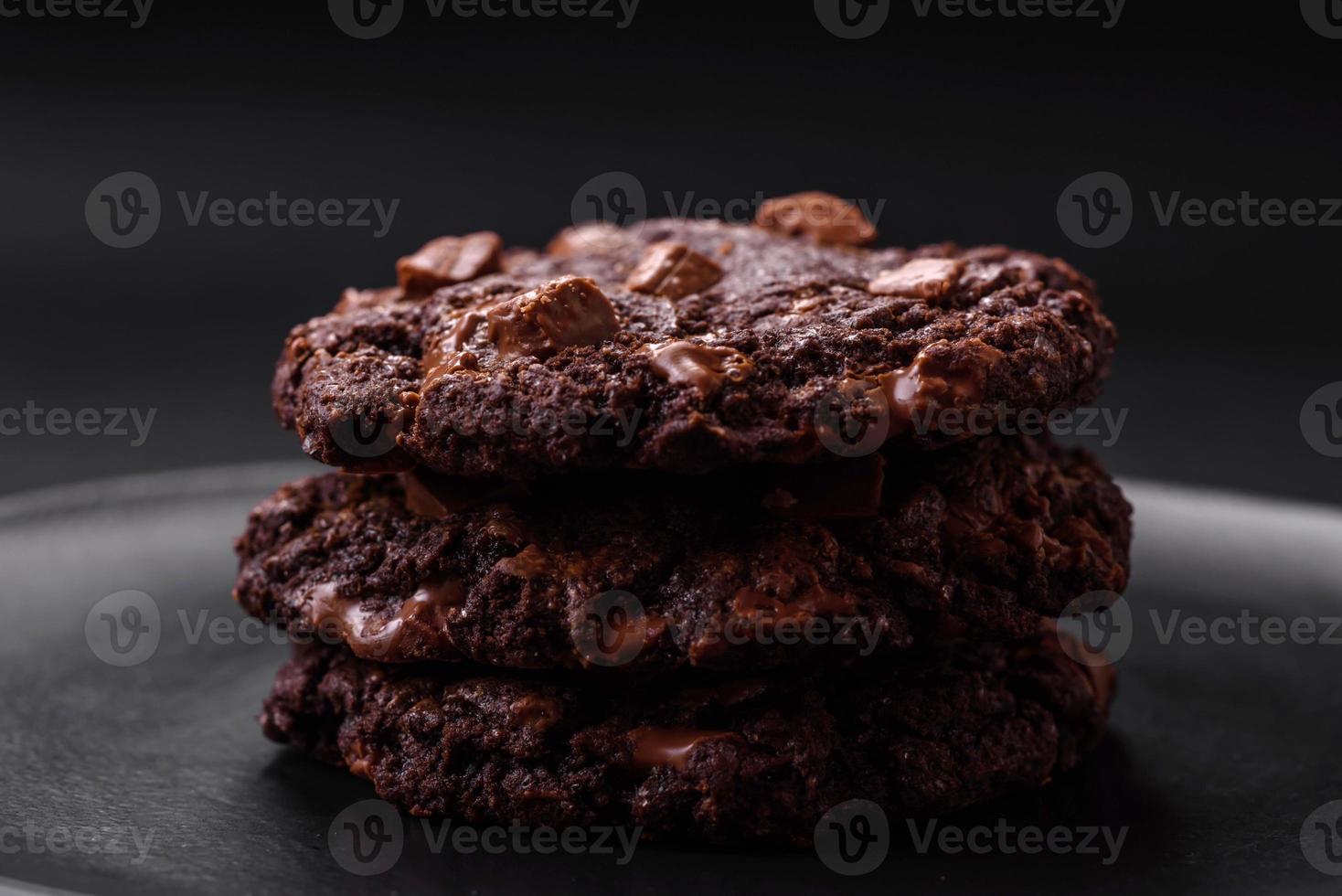 delicioso fresco aveia volta biscoitos com chocolate em uma Preto cerâmico prato foto