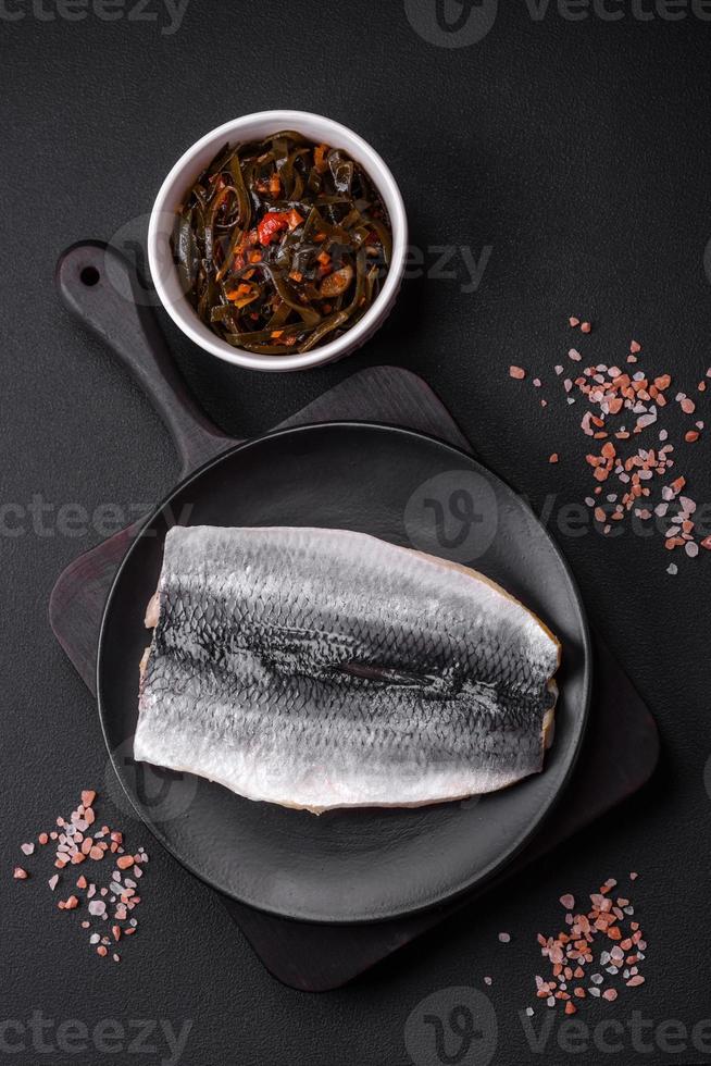 delicioso salgado arenque filé dentro óleo em uma Preto cerâmico prato foto