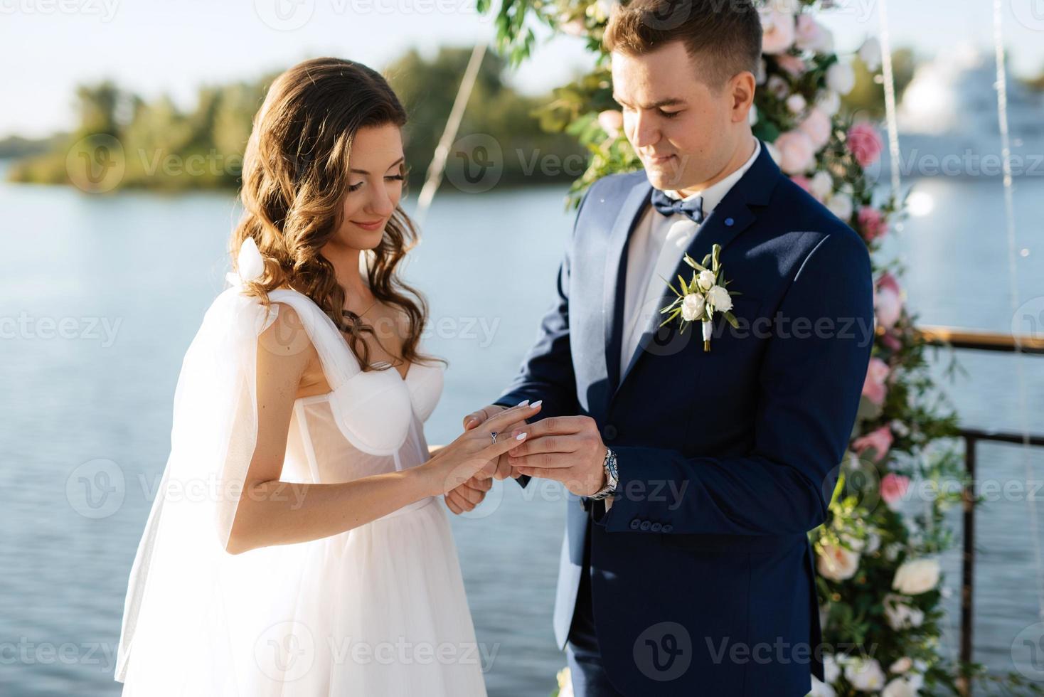 cerimônia de casamento em um píer alto perto do rio foto