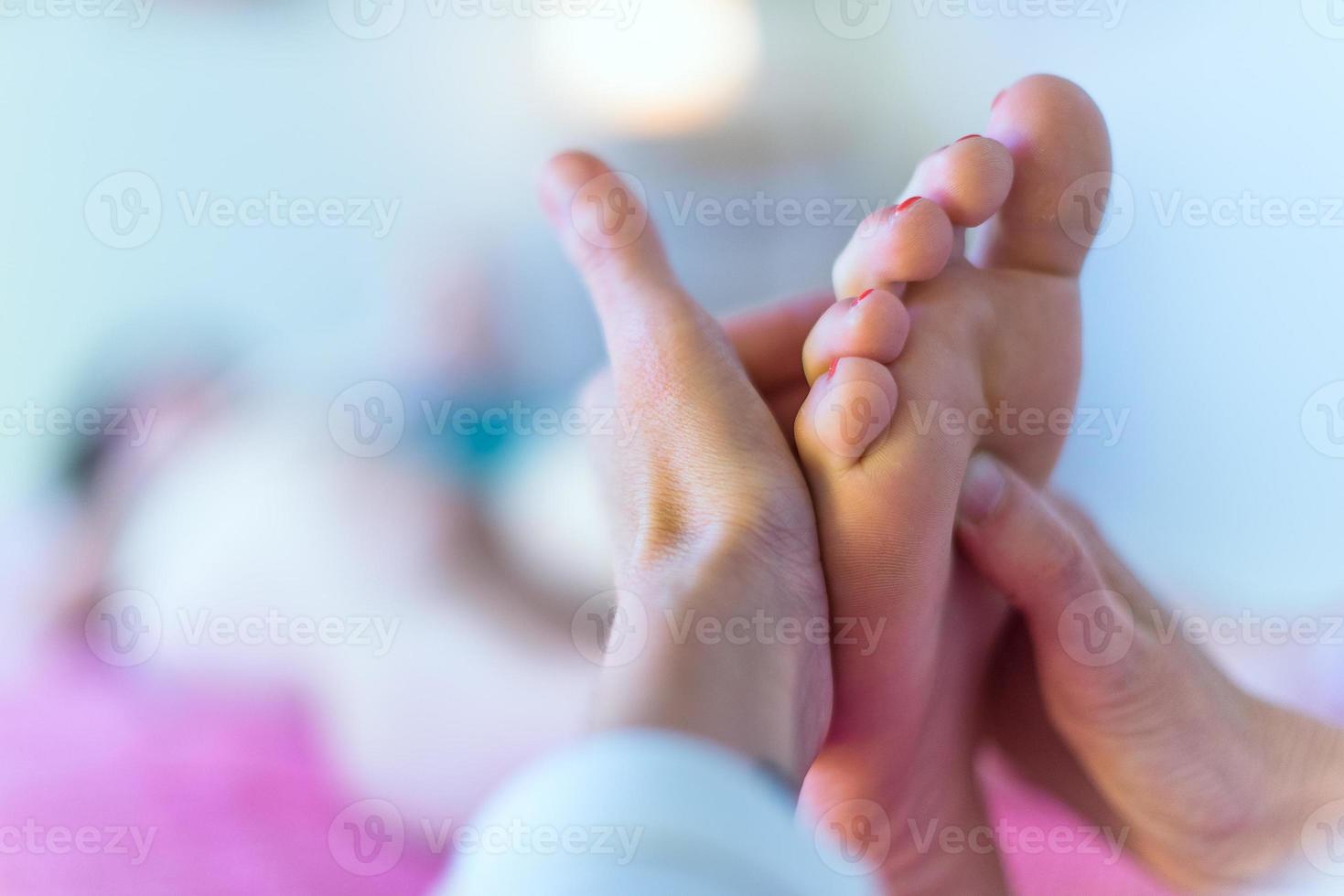 mãos de terapeuta massageando pé feminino foto