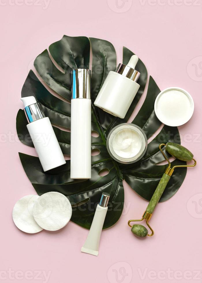 conjunto do cosméticos e jade massageador rolo para pele Cuidado e beleza com verde natureza folha. pele Cuidado e beleza produtos conceito foto