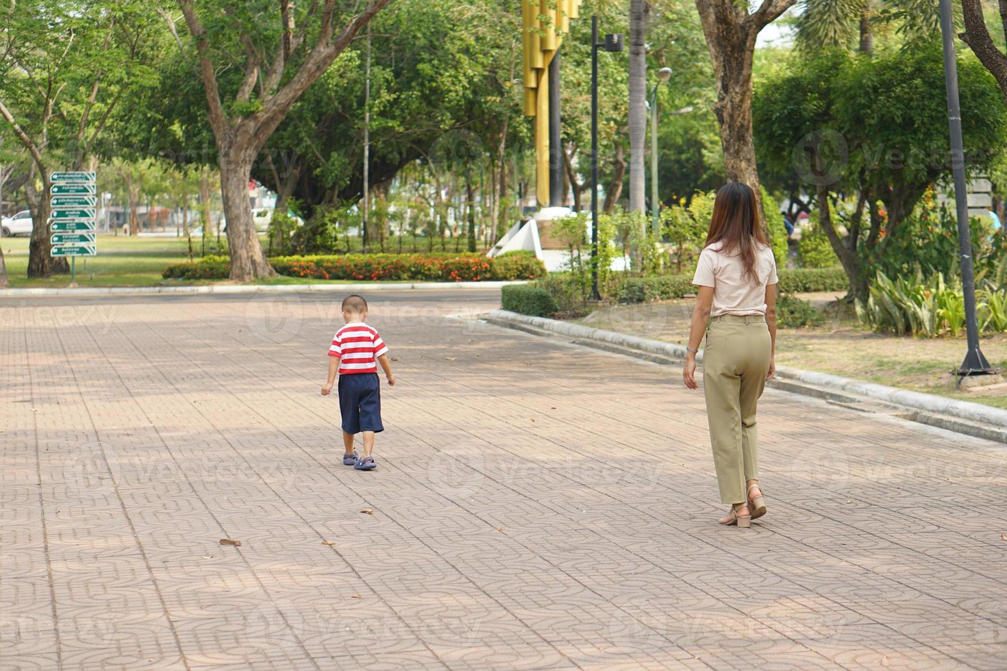 mãe leva bebê para uma andar dentro a parque feriado foto