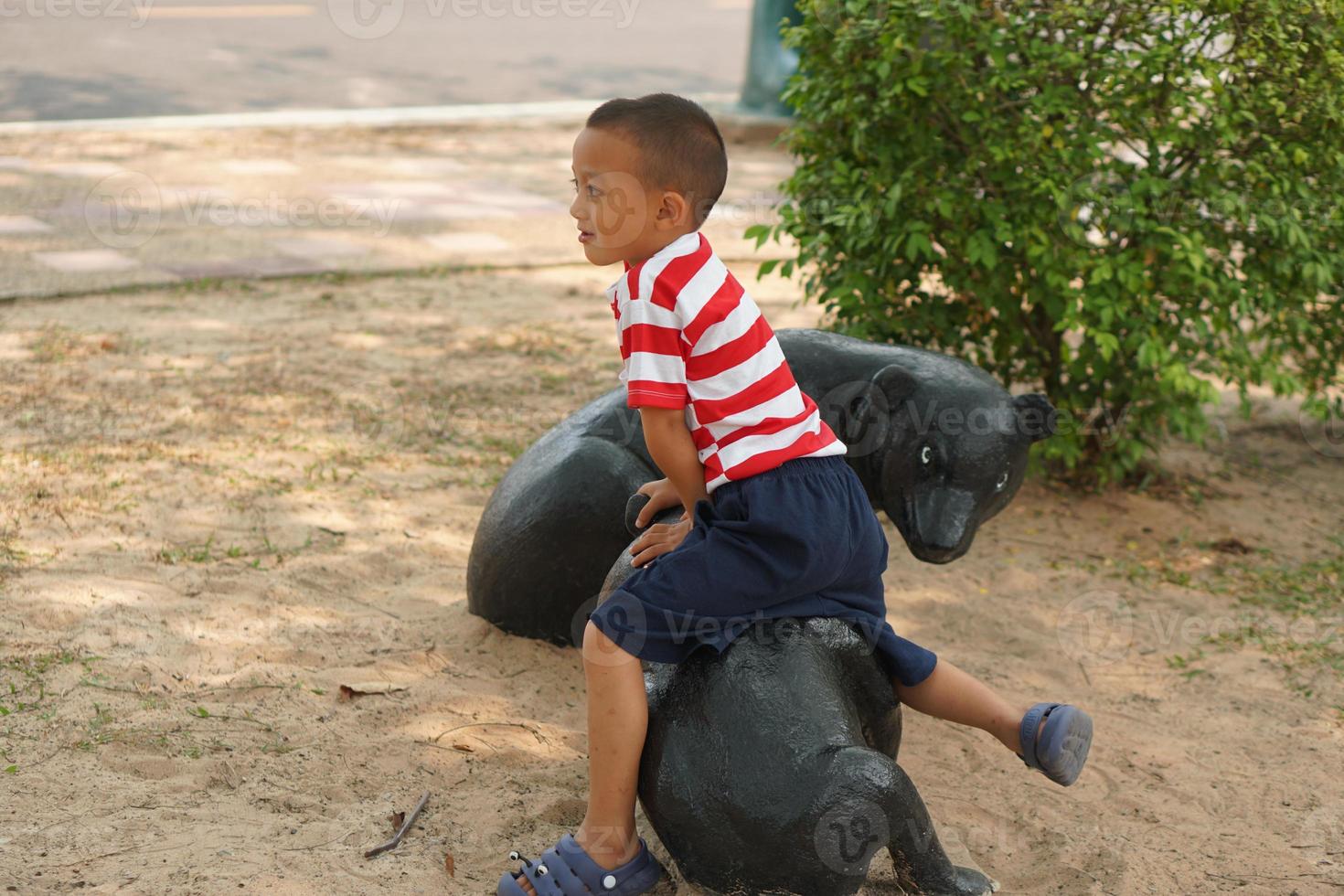 Garoto jogando dentro a Parque infantil dentro a parque foto