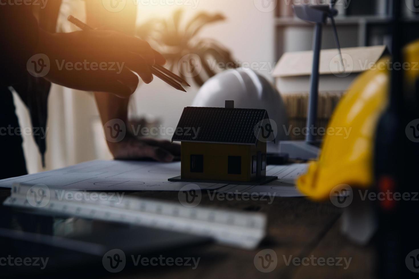 engenheiro de canteiro de obras de dois homens de negócios. objetos de engenharia no local de trabalho com parceiros interagindo em segundo plano foto