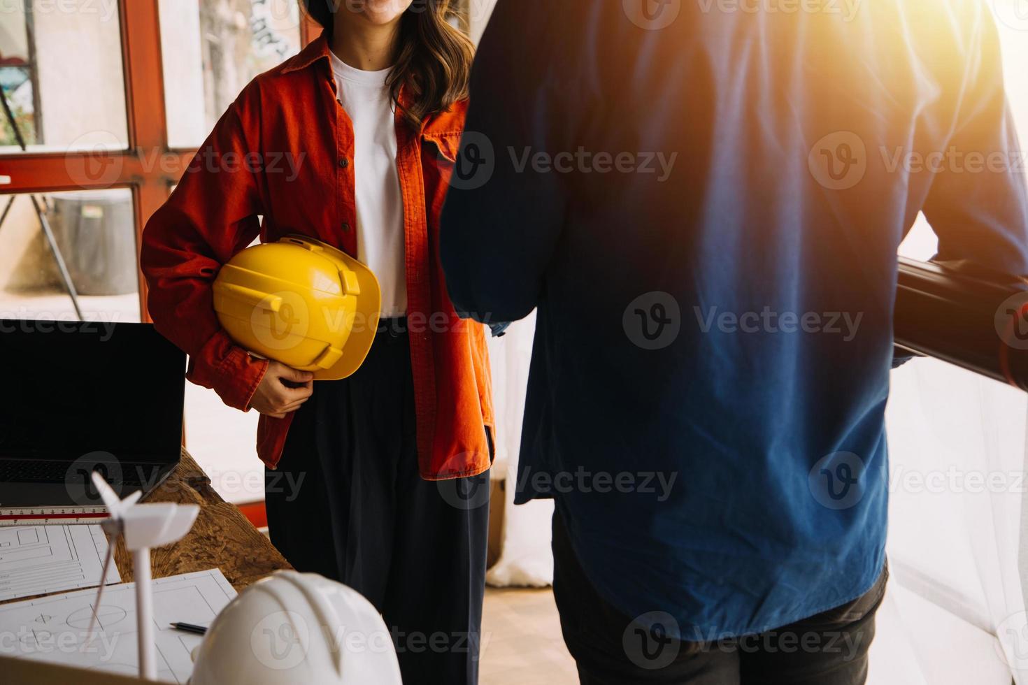 engenheiro de canteiro de obras de dois homens de negócios. objetos de engenharia no local de trabalho com parceiros interagindo em segundo plano foto