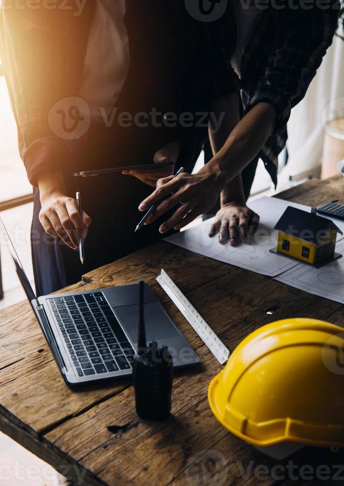 engenheiro de canteiro de obras de dois homens de negócios. objetos de engenharia no local de trabalho com parceiros interagindo em segundo plano foto