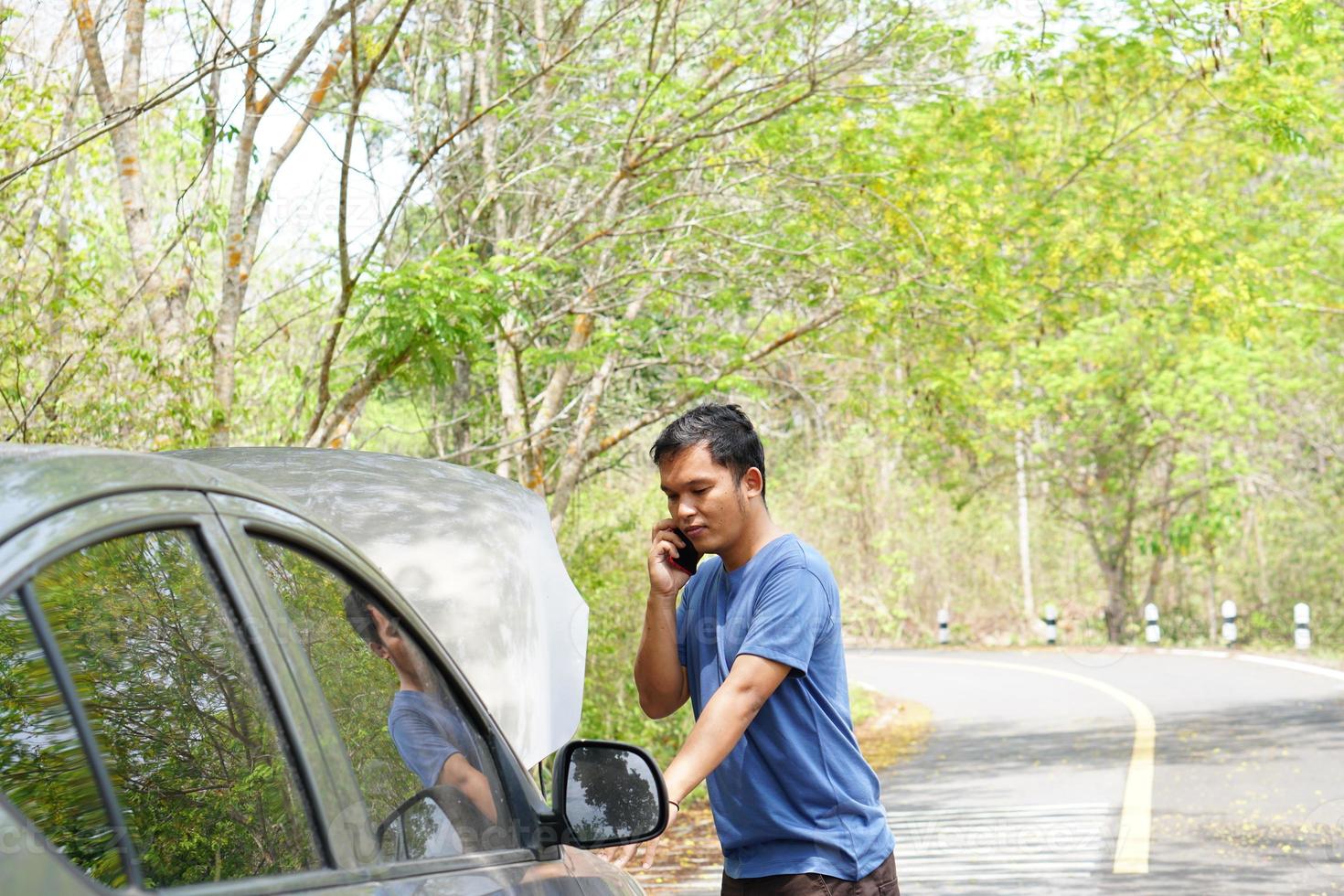 homem chamado uma mecânico para venha Veja às a quebrado carro. foto