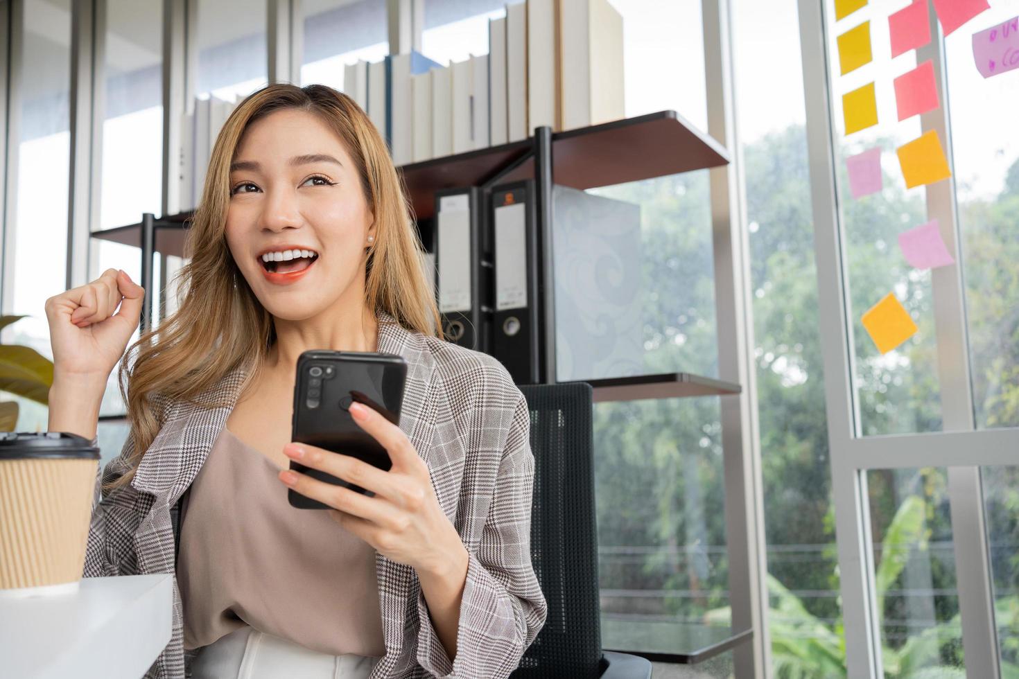 feliz jovem empreendedora de inicialização de mulheres asiáticas feliz e animada sorrindo depois de receber mensagem para contato de negócios de sinal de sucesso, garota feliz no local de trabalho. ensino à distância educação on-line e trabalho. foto