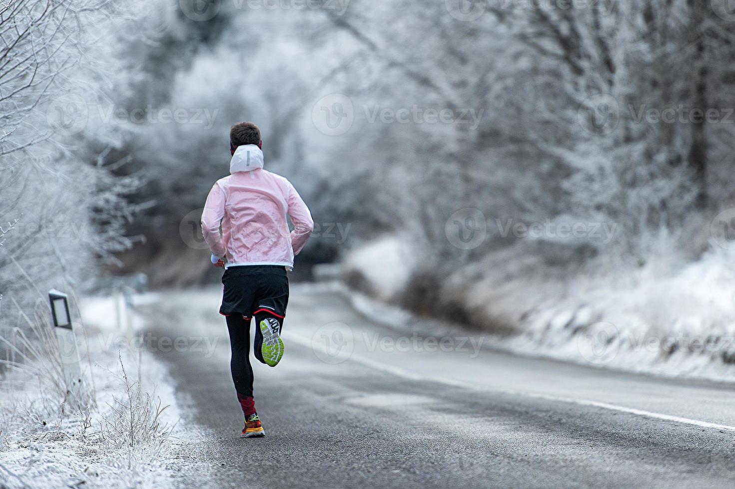 corredor durante o treinamento em estrada gelada no inverno foto