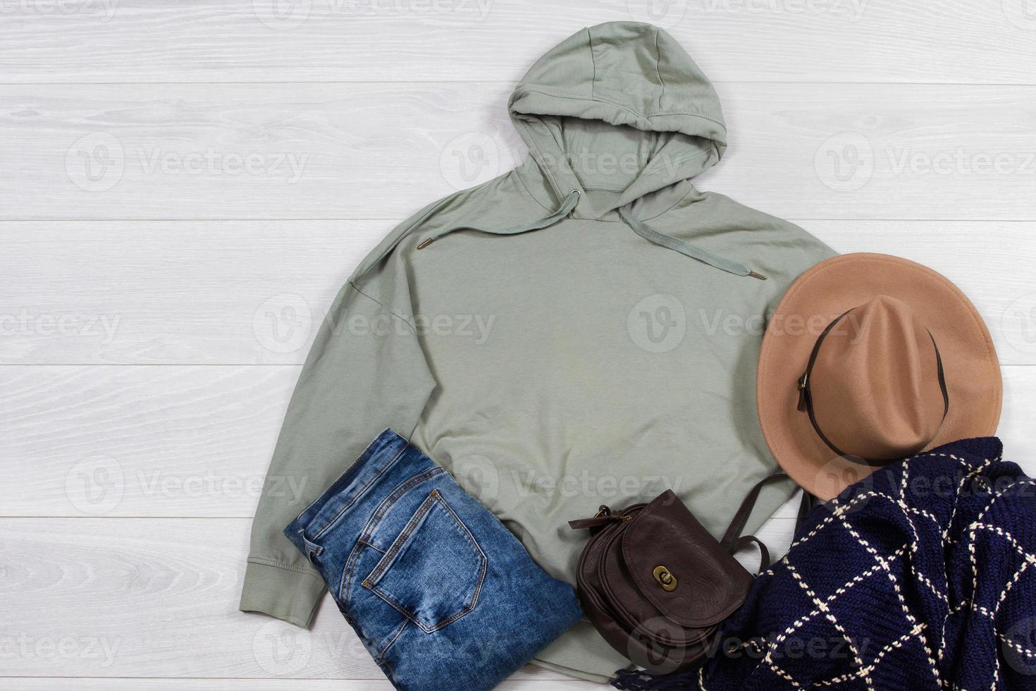 suéter brincar. modelo em branco cáqui moletom com capuz camisa topo Visão em branco de madeira fundo. inverno equipamento em madeira chão. mulher moda roupas. Primavera Veja do hoje. fêmea jeans, bolsa, cachecol acessórios foto