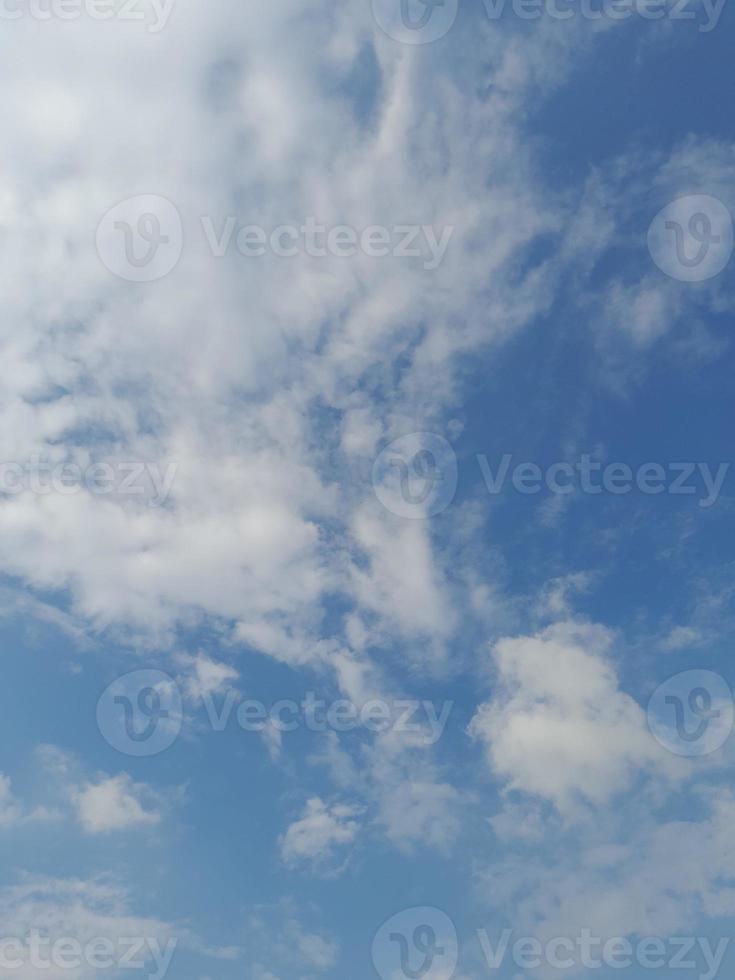 lindas nuvens brancas sobre fundo de céu azul profundo. grandes nuvens fofas e brilhantes cobrem todo o céu azul. foto