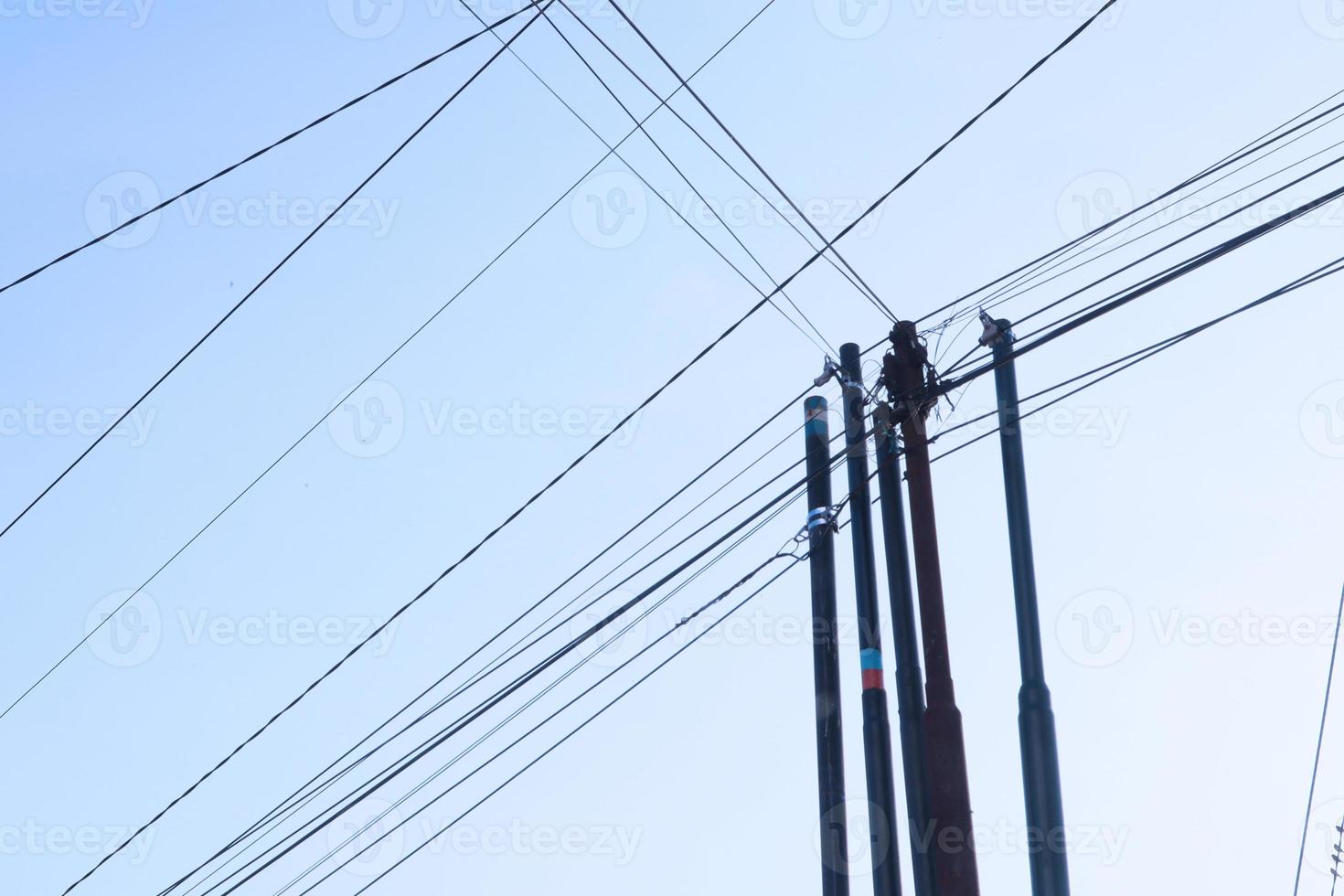 emaranhado fio em elétrico torre contra a azul céu fundo parece tão bagunçado foto