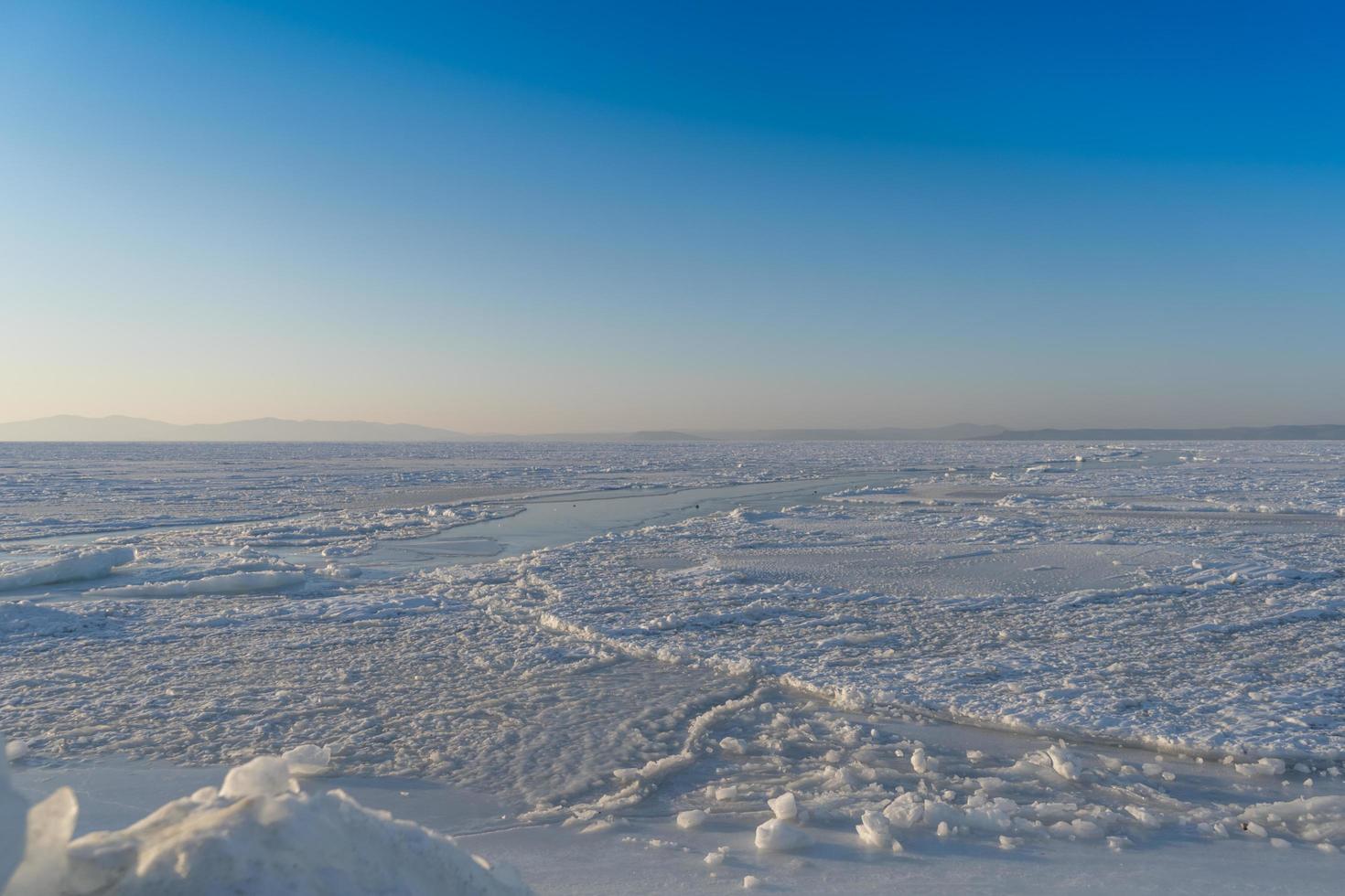 panorama da baía de amur congelado com neve e blocos de gelo em vladivostok, rússia foto