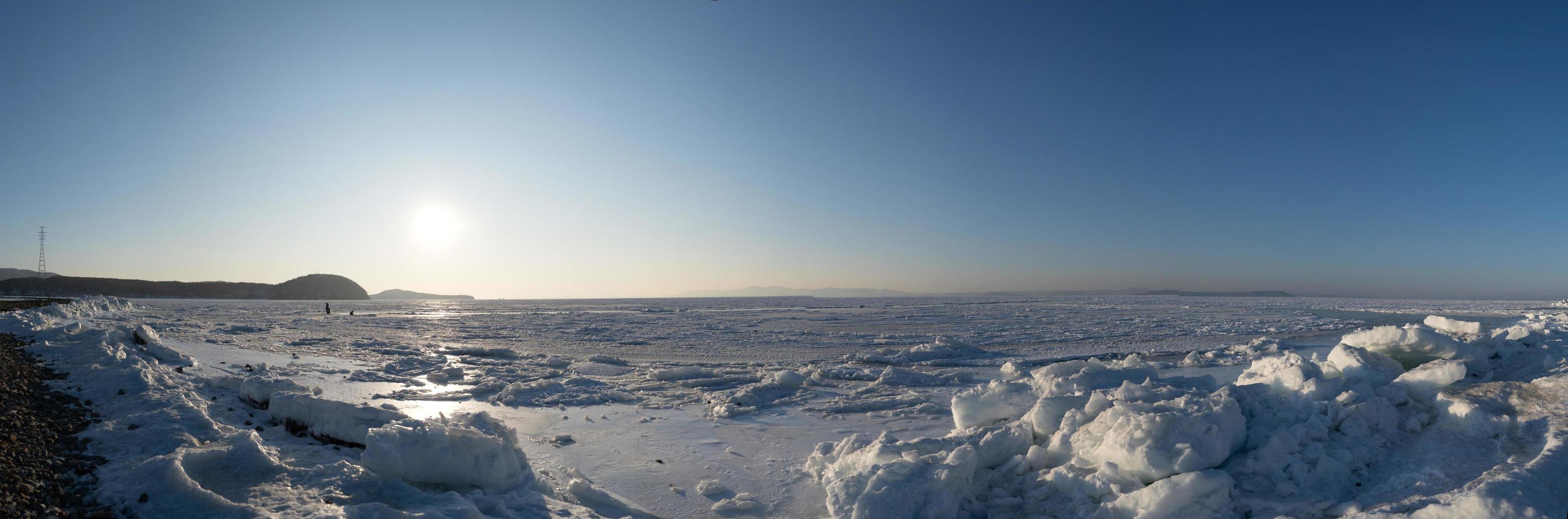 panorama da baía de amur congelado com neve e blocos de gelo em vladivostok, rússia foto