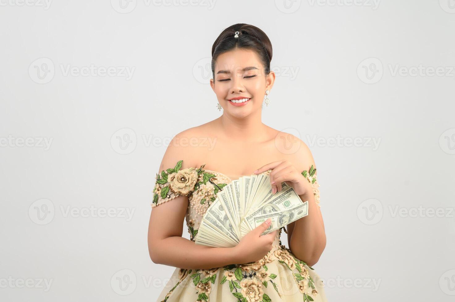 jovem noiva linda asiática segurando notas de dólar na mão foto