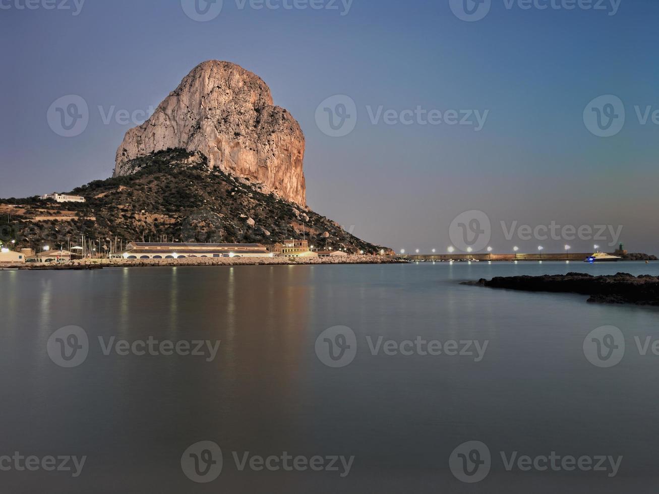 praia mediterrânea ao pôr do sol com o penon ao fundo em calpe, alicante foto