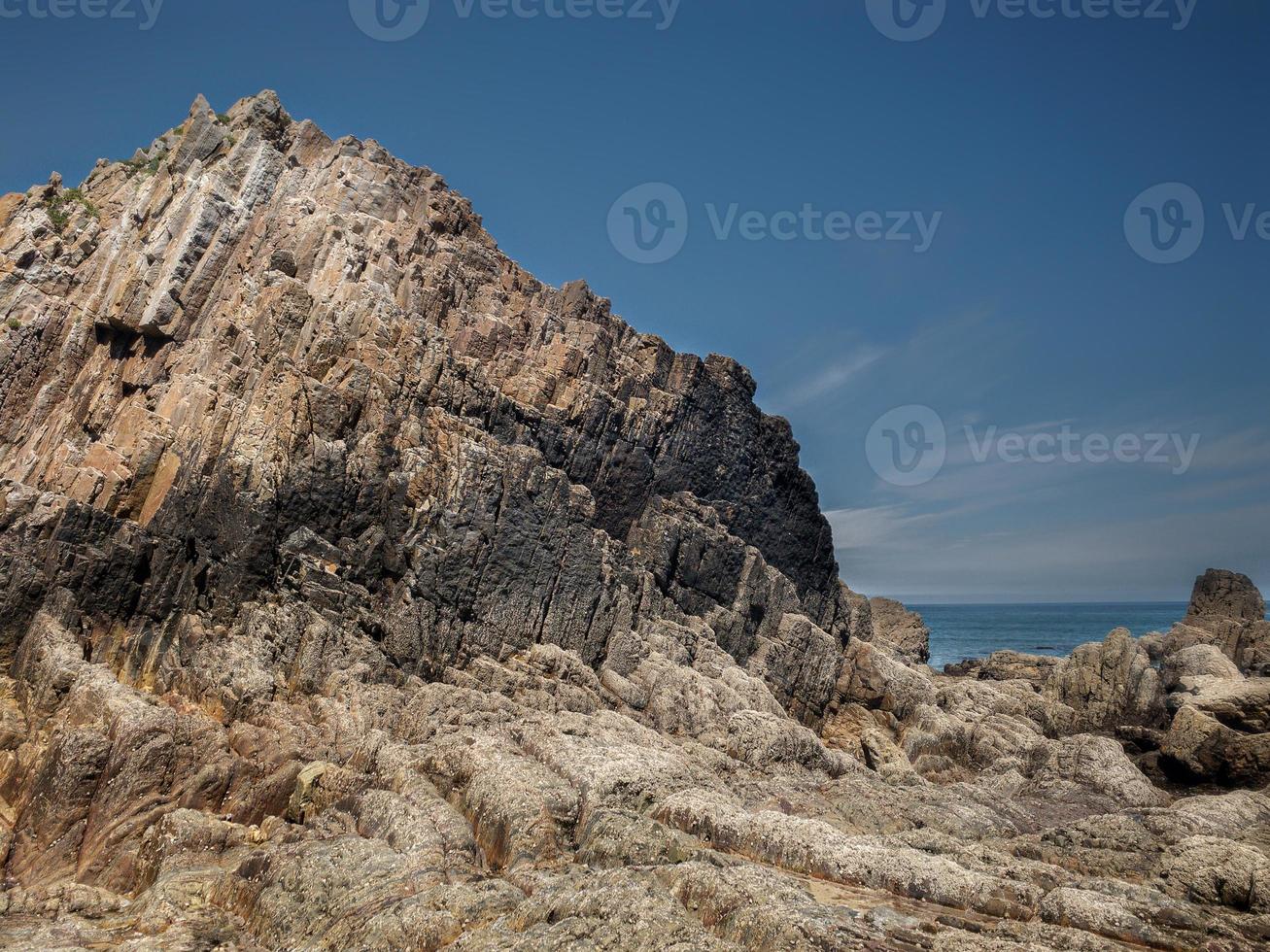 rochas com bordas retas na maré baixa de uma praia na costa asturiana foto