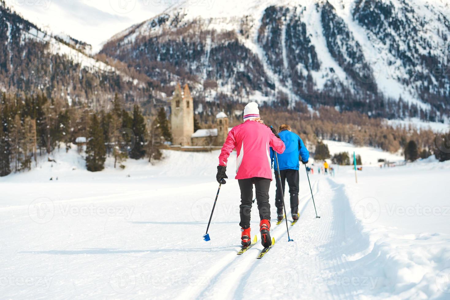 casal de idosos pratica esqui cross-country foto