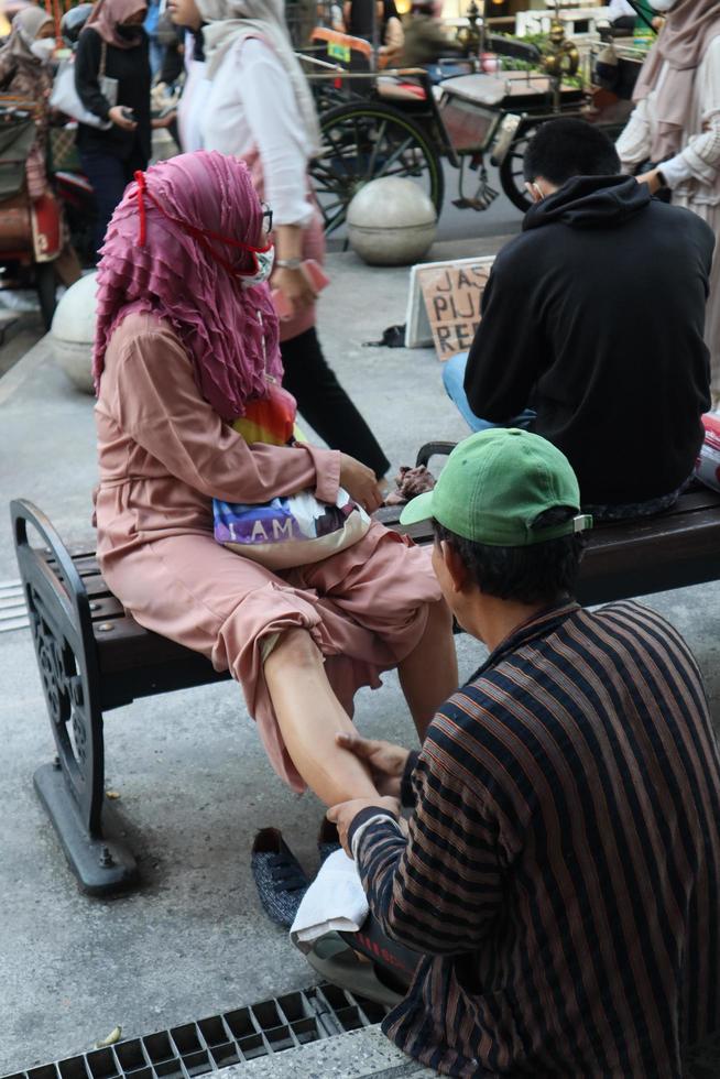 a terapeuta do javanese rua massagem dar massagem para turistas e viajante foto