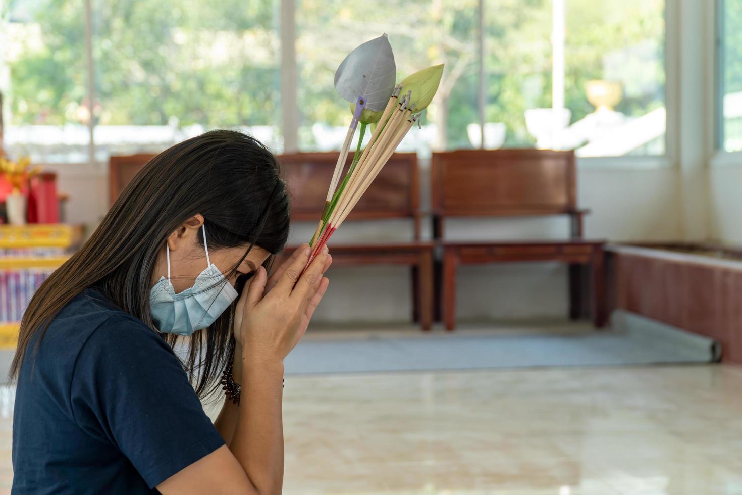 jovem mulher asiática fazendo um pedido em um templo, conceito de vida, esperança, crença e boa sorte foto