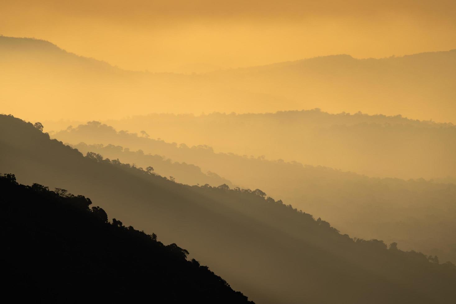 silhuetas de montanhas ao pôr do sol foto