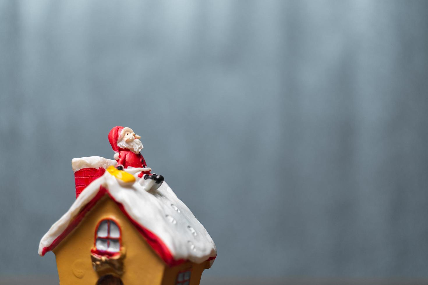 miniatura do papai noel sentado no telhado, lenda do natal e conceito de boas festas foto