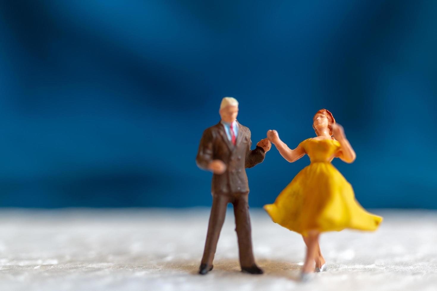 casal em miniatura dançando no chão, conceito de dia dos namorados foto