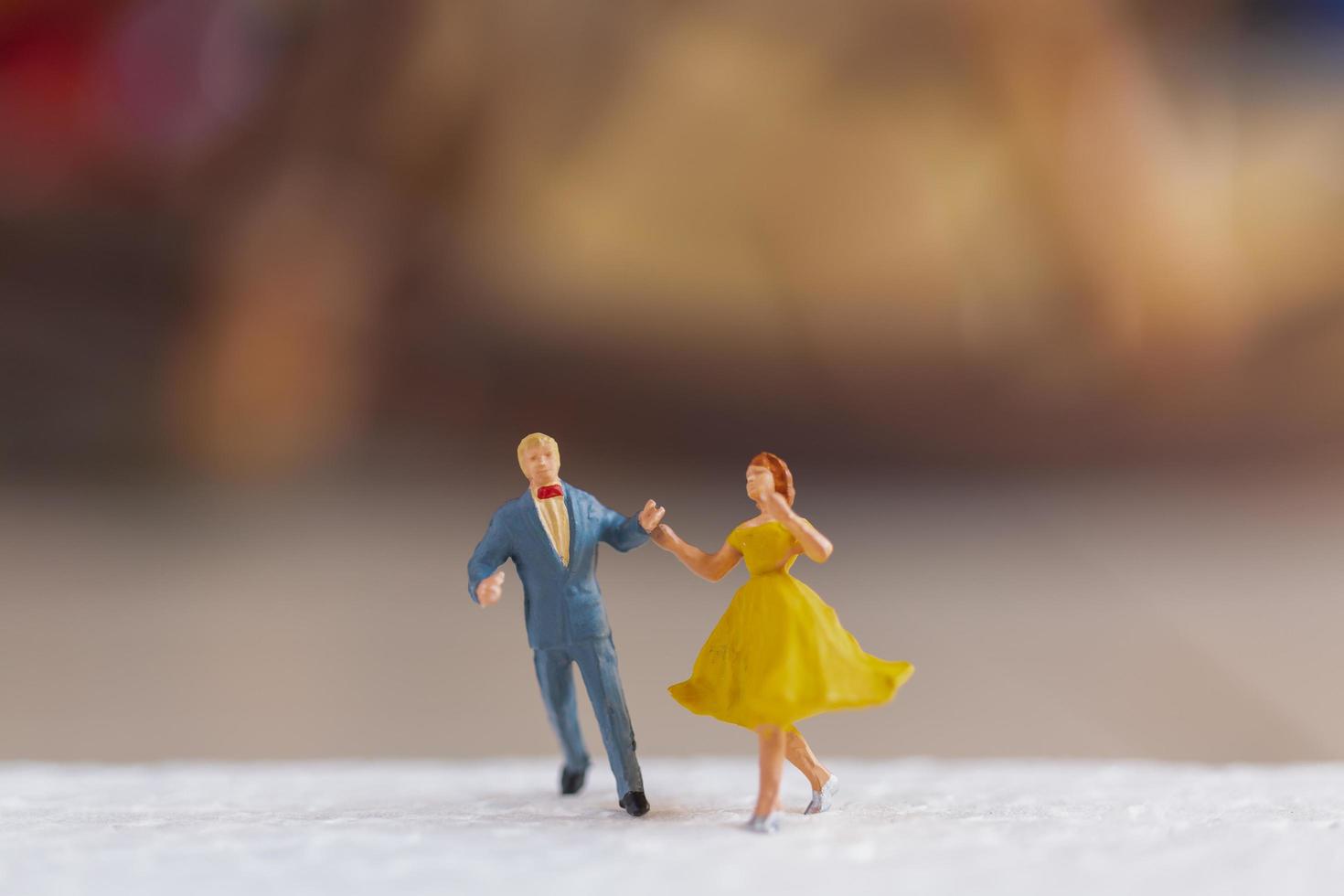 casal em miniatura dançando no chão, conceito de dia dos namorados foto