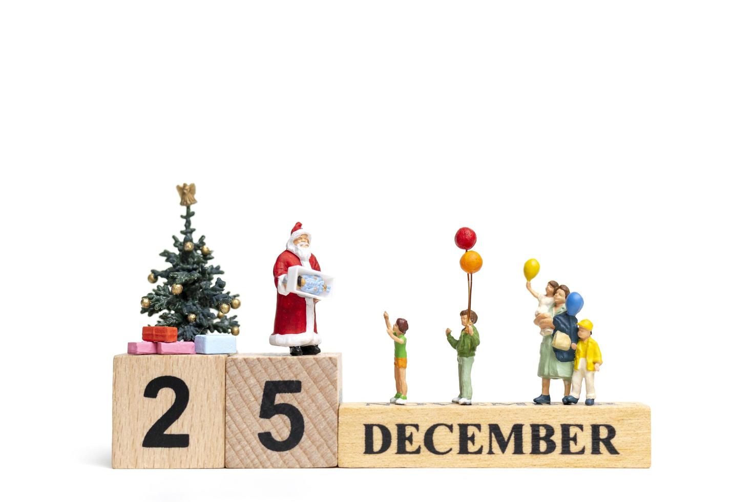 miniatura do papai noel segurando presentes para uma família feliz, conceito de natal e feliz ano novo foto