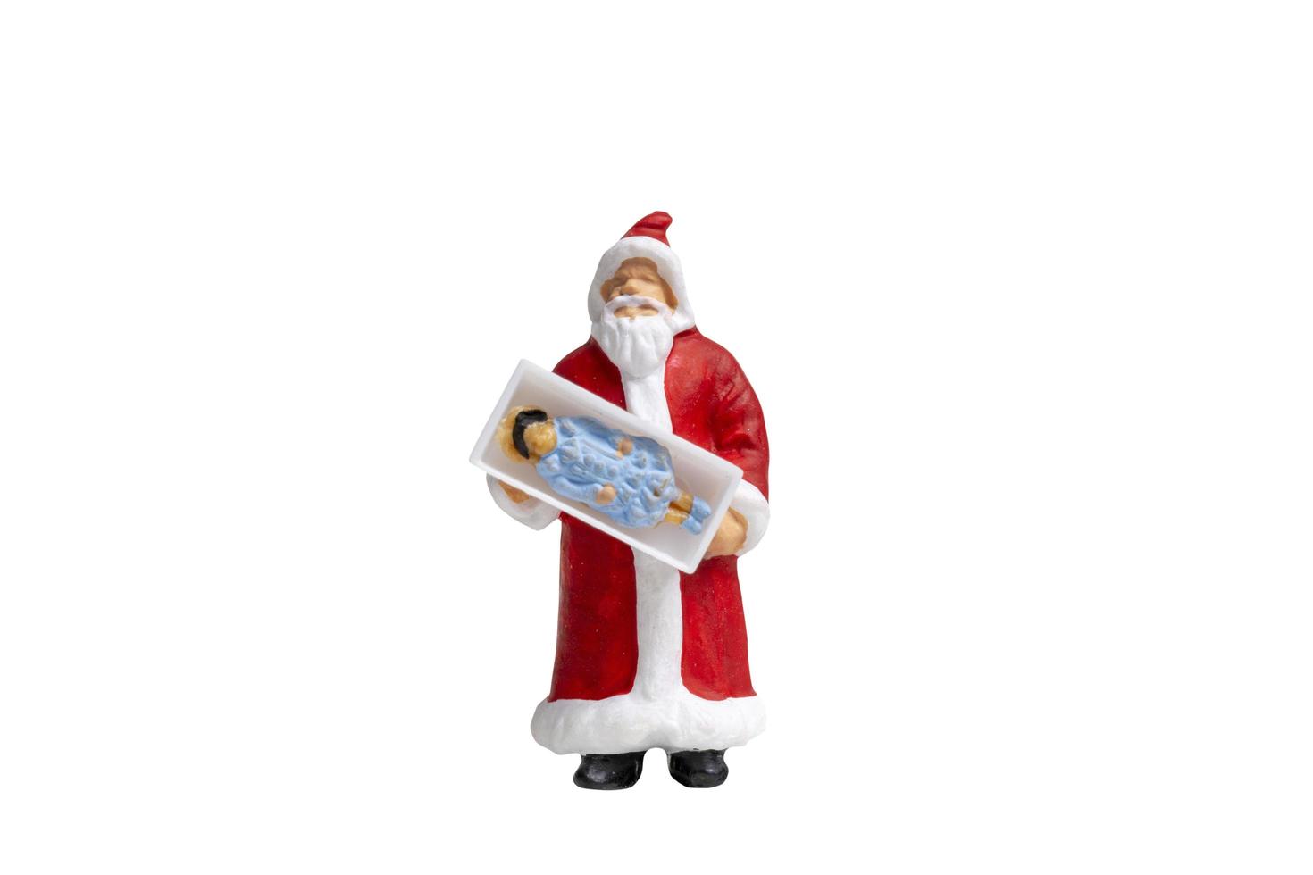 Papai Noel em miniatura segurando uma caixa de presente isolada em um fundo branco foto