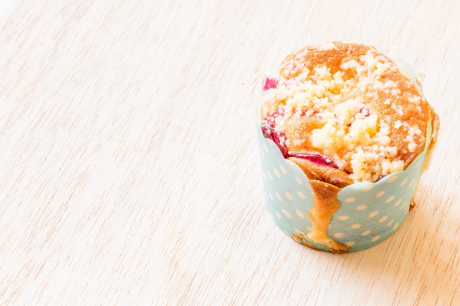 muffins de mirtilo em um cupcake de papel em um fundo de madeira foto