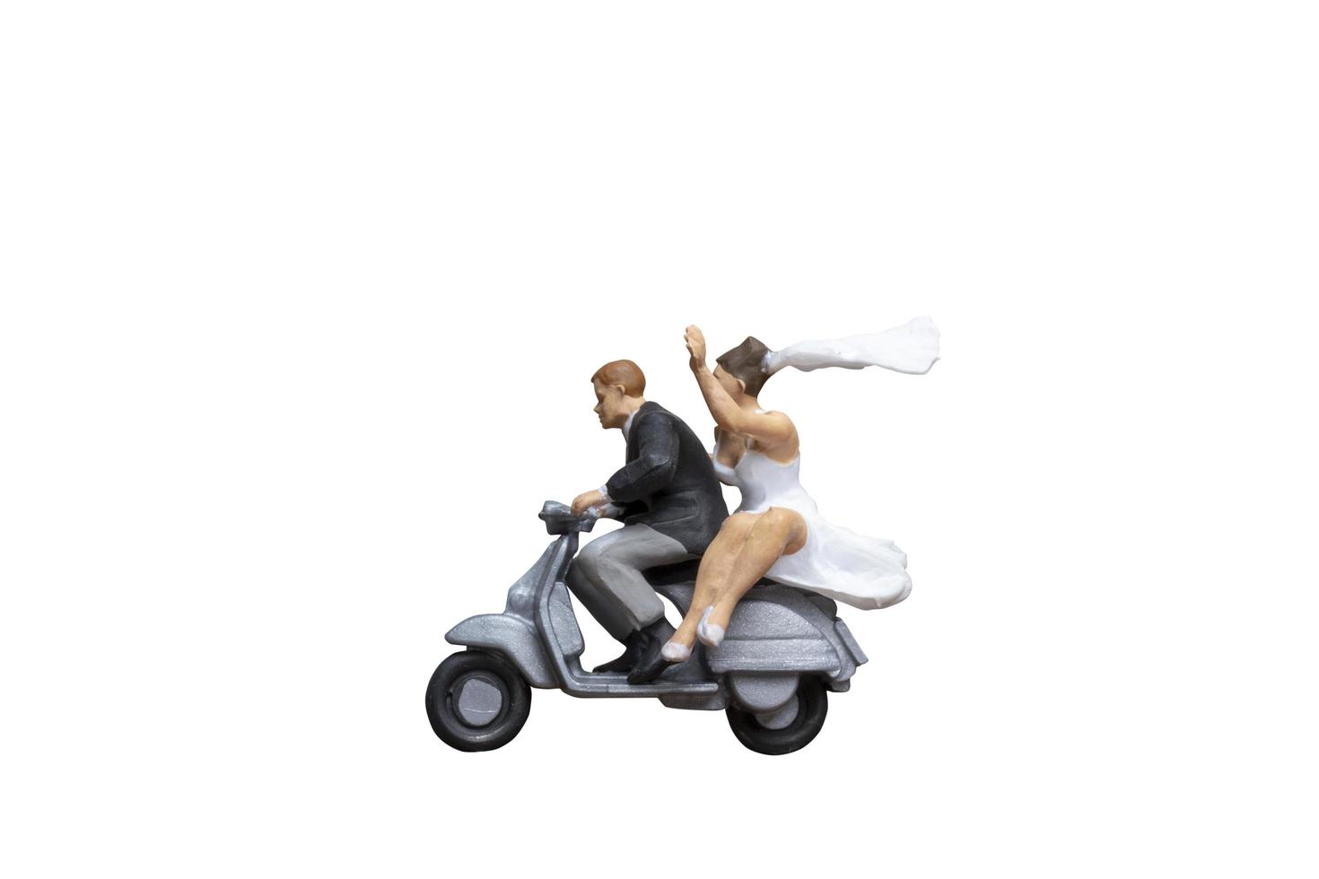 casal em miniatura andando de motocicleta isolado em um fundo branco foto