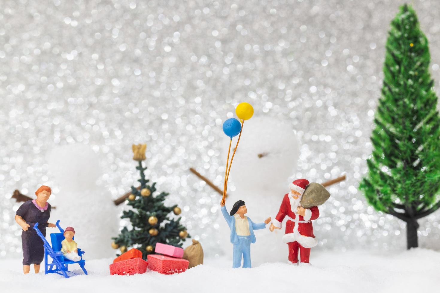 miniatura do papai noel e crianças com um fundo de neve, conceito de natal e feliz ano novo foto