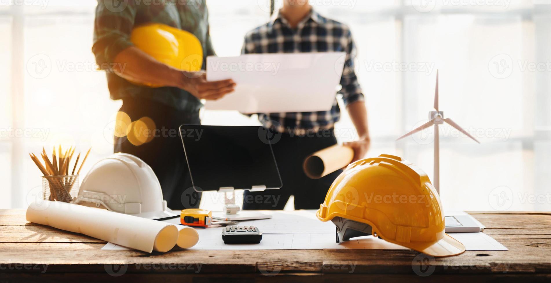 construção equipe mexe mãos cumprimento começar Novo projeto plano atrás amarelo capacete em escrivaninha dentro escritório para consulta sobre seus construção projeto.. foto