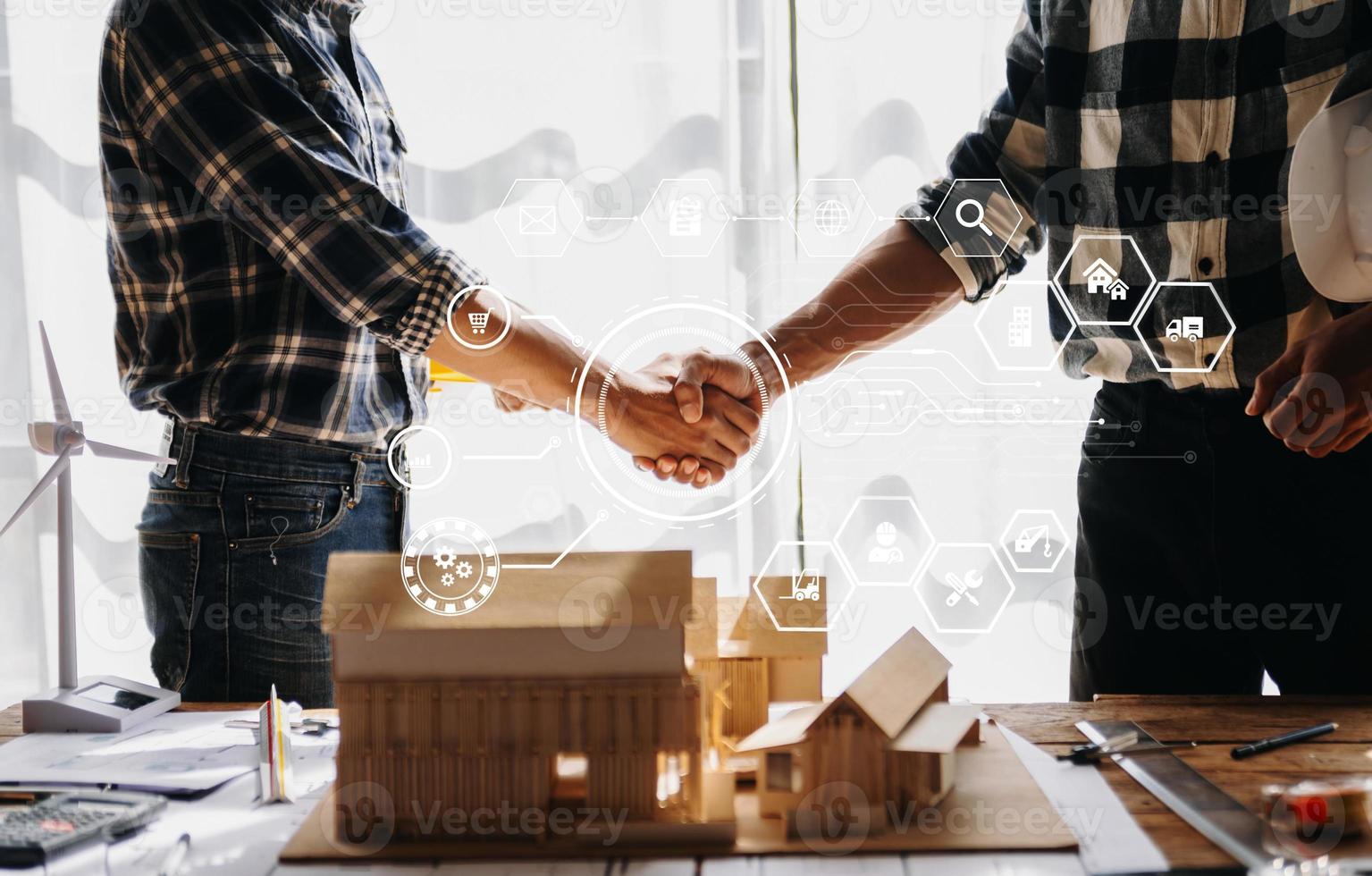 engenheiro e empreiteiro dão as mãos após a assinatura do contrato, eles estão tendo um projeto de construção moderno juntos. foto
