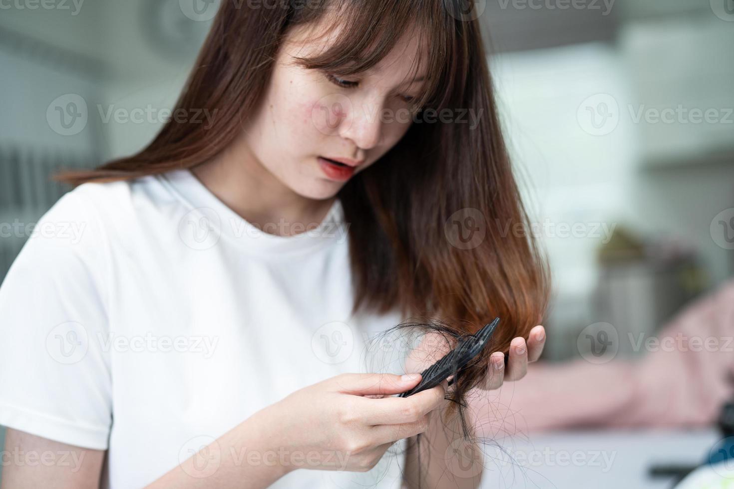 mulher asiática tem problema com perda de cabelo comprido anexar a escova de pente. foto