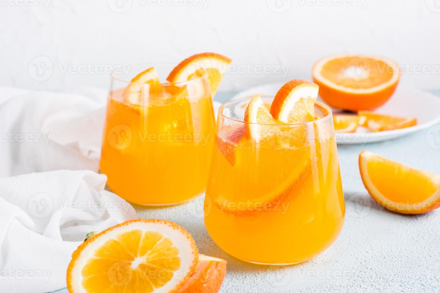 Difícil seltzer carbonatado laranja coquetel com gelo dentro óculos e laranja fatias em a mesa. caseiro bebida. foto