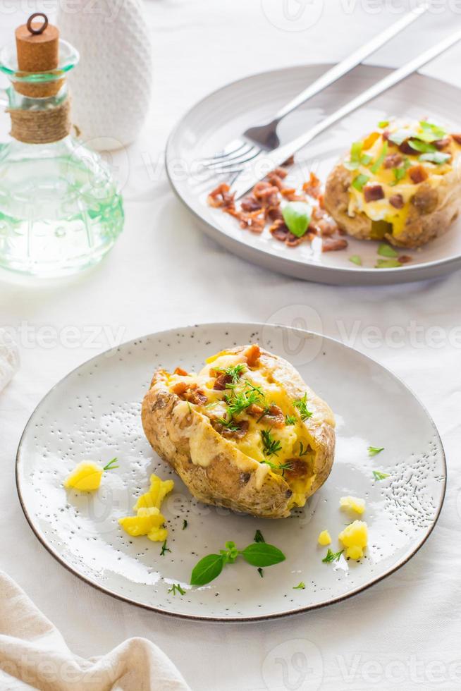 assado duas vezes batatas dentro seus peles com queijo e bacon migalhas em pratos em uma de madeira mesa. flexitarista dieta. vertical muito foto