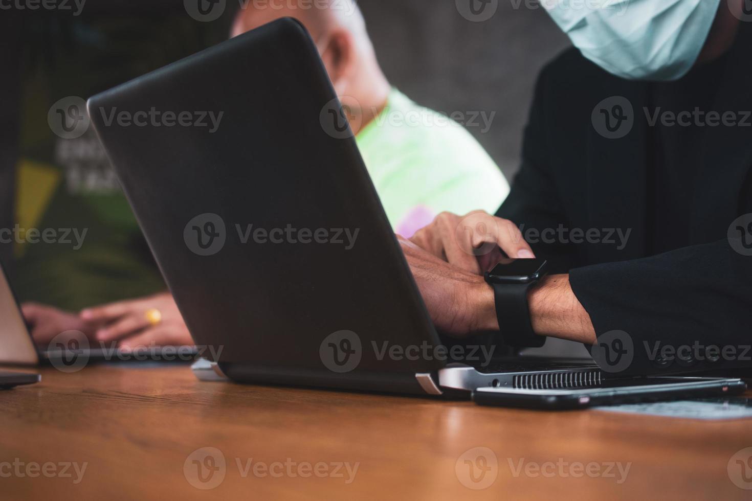 duas pessoas conversando no escritório e trabalhando com notebooks de computador foto