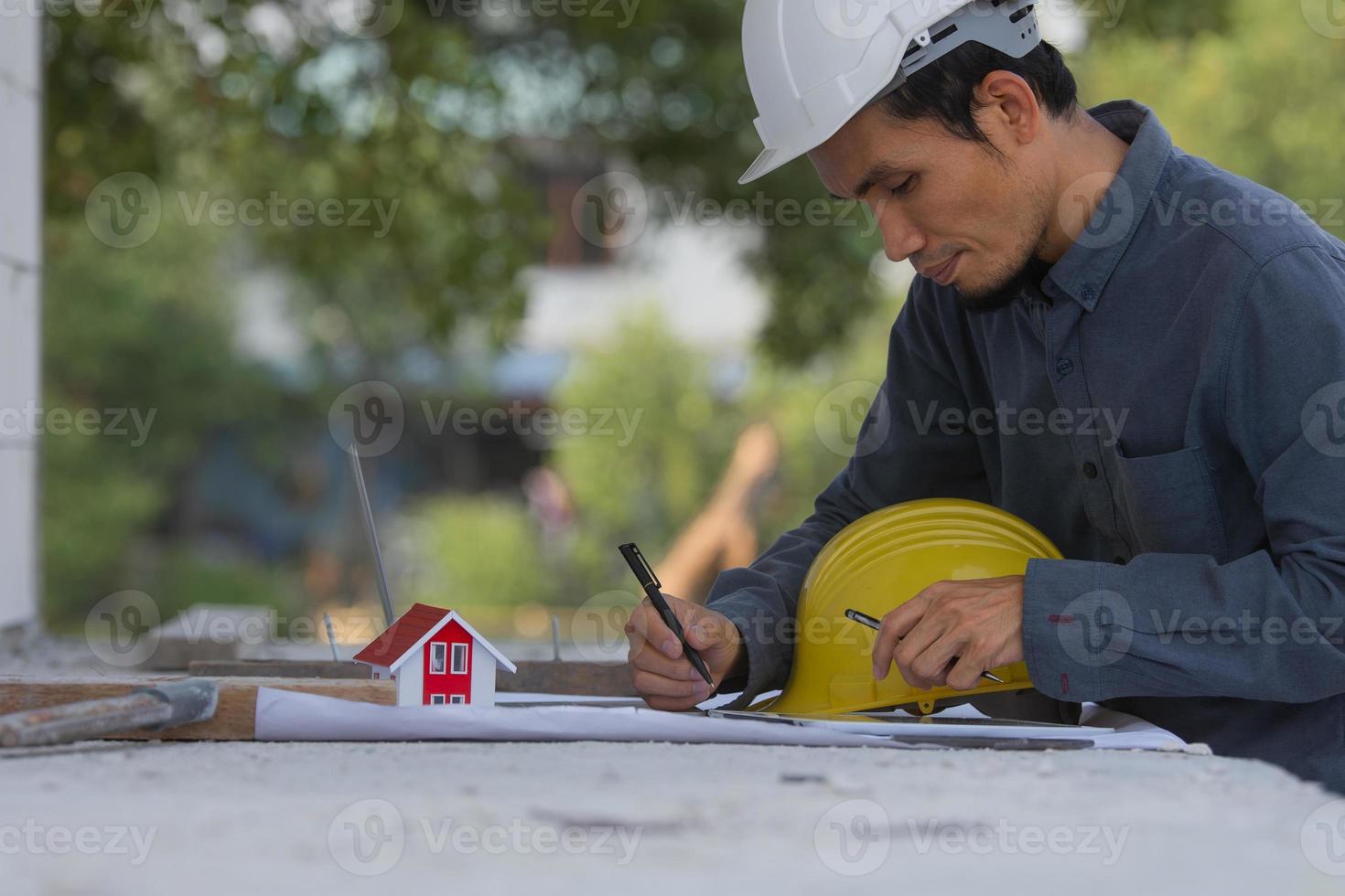 engenheiro trabalhando em tablet e laptop na construção do local foto