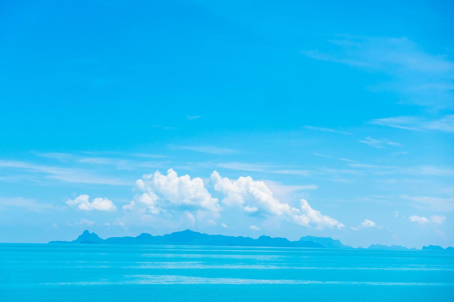 lindo oceano com nuvens no céu azul foto