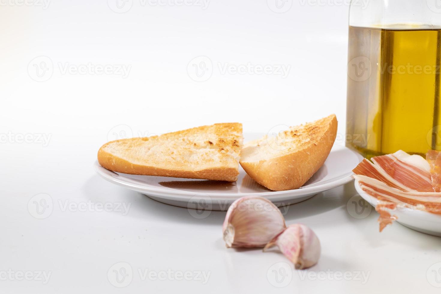 pão, alho e azeite no fundo branco foto