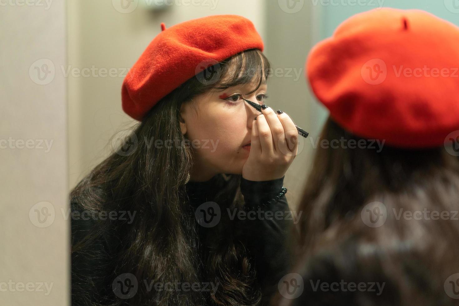 jovem elegante fazendo sua maquiagem com delineador foto