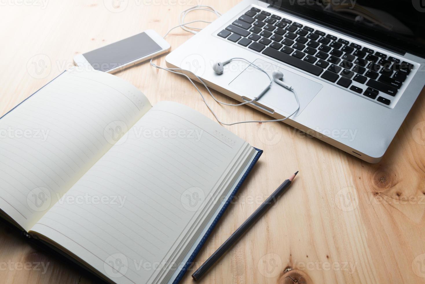em branco caderno com lápis e computador portátil foto