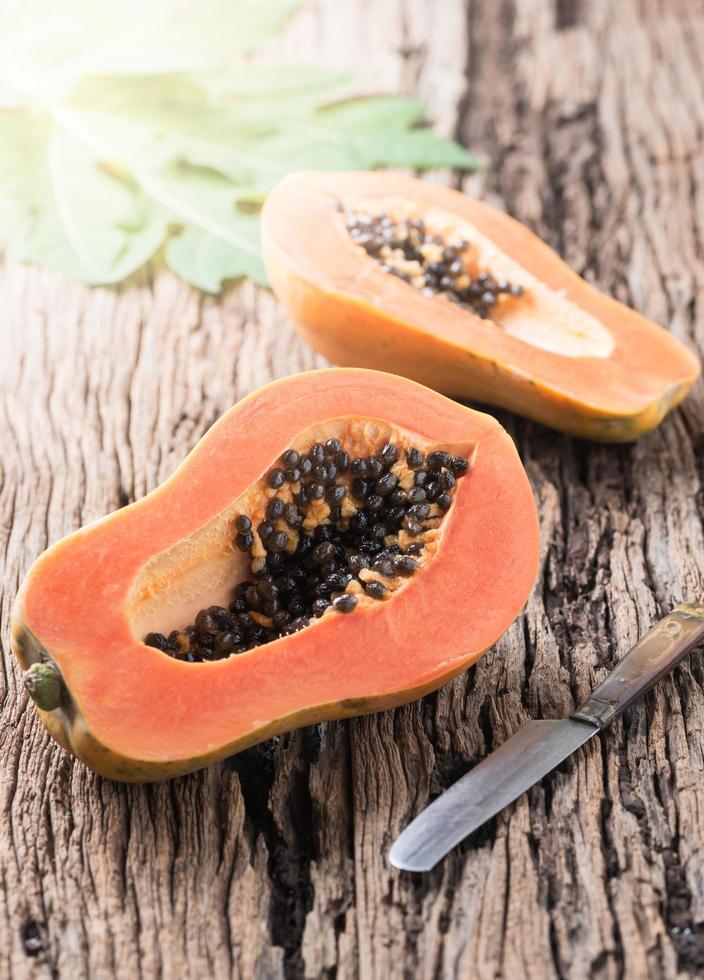 fatiado mamão fresco fruta em madeira fundo foto